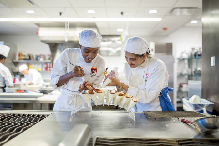 Culinary students using piping bags.