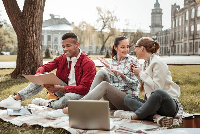 college students sitting outside on campus
